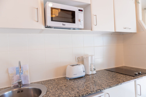 Moderne witte keuken bij Camping del Mar BUNGALOW MEDITERRANI in Spanje met magnetron en broodrooster.