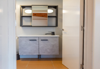 Modern bathroom at Camping del Mar BUNGALOW MEDITERRANI, Spain, featuring a mirror and cabinet