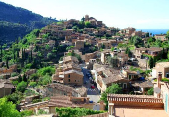 View of a charming Spanish hillside village with stone houses and lush greenery near Camping del Mar BUNGALOW MEDITERRANI.