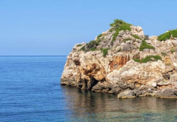 Rocky coastline by Camping del Mar BUNGALOW MEDITERRANI in Spain, blue sky and clear Mediterranean Sea.