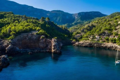 Prachtig kustuitzicht vanaf Camping del Mar BUNGALOW MEDITERRANI in Spanje met groene heuvels en blauw water.