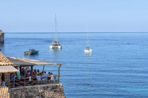 Uitzicht vanaf Camping del Mar BUNGALOW MEDITERRANI in Spanje met boten en etende mensen op een terras.
