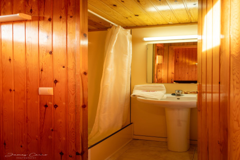 Baño en una cabaña de madera con ducha y lavabo, Vilanova Park BUNGALOW 4 PAX S150, España.