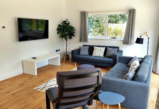 Stilfuld stue i Little Dunley - Apple Lodge, UK, med moderne sofaer, lænestol og stort vindue.