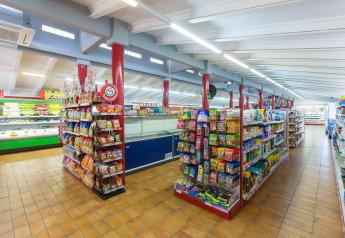Imagen del interior de un supermercado bien iluminado con pasillos llenos en un alojamiento glamping.