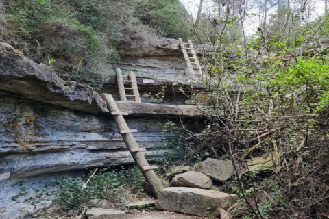 Dos escaleras de madera apoyadas en un acantilado rocoso cerca de Vilanova Park BUNGALOW 4 PAX S150, España.