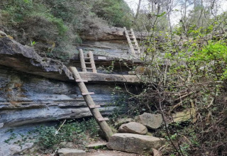 Dos escaleras de madera apoyadas en un acantilado rocoso cerca de Vilanova Park BUNGALOW 4 PAX S150, España.