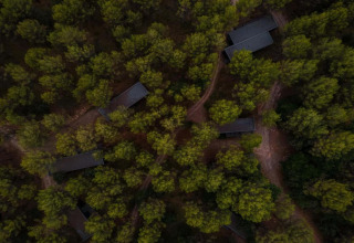 Vista aérea del Vilanova Park BUNGALOW 4 PAX S150 en España, rodeado de bosque frondoso y senderos.