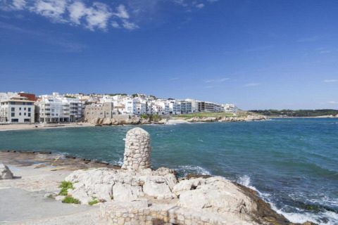 Coastal view from Nomad Paraiso in Spain, showing blue sky, ocean, and white buildings along the shore.