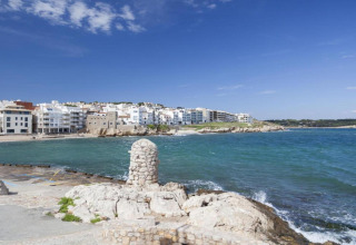 Coastal view from Nomad Paraiso in Spain, showing blue sky, ocean, and white buildings along the shore.