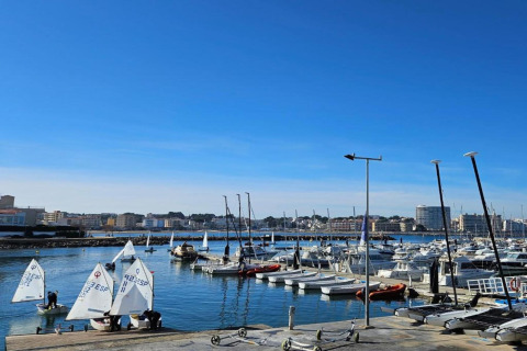 View of the marina at Nomad Paraiso in Spain with sailboats and yachts under a clear blue sky.