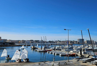 View of the marina at Nomad Paraiso in Spain with sailboats and yachts under a clear blue sky.