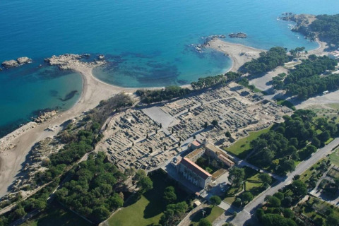 Aerial view of archaeological ruins by the coast in Spain, surrounded by beach and sea at Nomad Paraiso.