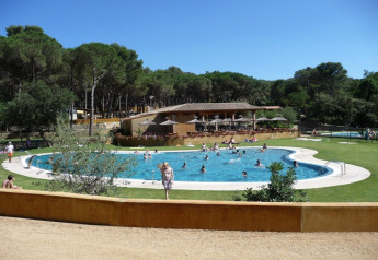 Schwimmbad mit Gästen im Resort Begur 1 in Spanien, umgeben von Wald und einer sonnigen Atmosphäre.