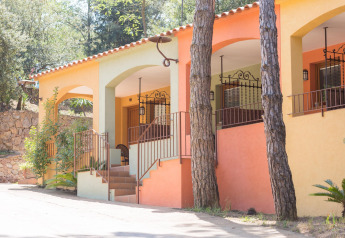 Bunte Veranda von Resort Begur 1 in Spanien mit Natur, Bäumen und charmantem Außendesign.