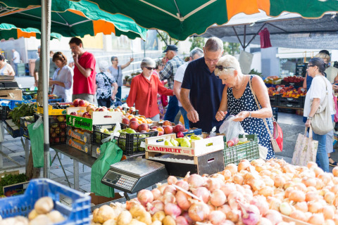 Mensen winkelen voor verse groenten en fruit op een levendige markt bij Resort Begur 1, Spanje.