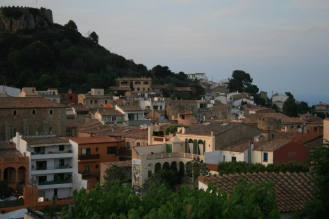 Zicht op daken en bos vanuit een safaritent in Resort Begur 1 in Spanje bij zonsondergang.