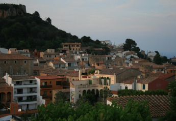 Blick auf die Dächer und den Wald von einem Safarizelt im Resort Begur 1 in Spanien bei Sonnenuntergang.