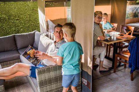 Family enjoying time together inside a safari tent suite at Resort Begur 3 in Spain, relaxing and talking.