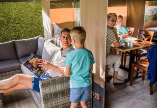 Famille passant du temps dans une tente safari du Resort Begur 3 en Espagne, détendue et en discussion.