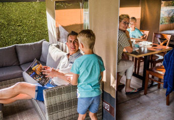Famille passant du temps dans une tente safari du Resort Begur 3 en Espagne, détendue et en discussion.