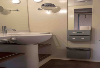 Bathroom with a modern sink, mirror, and shelves inside a safari tent at Resort “Begur 3” in Spain.