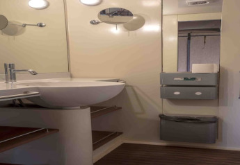 Salle de bain avec lavabo moderne, miroir et étagères dans une tente safari au Resort «Begur 3» en Espagne.
