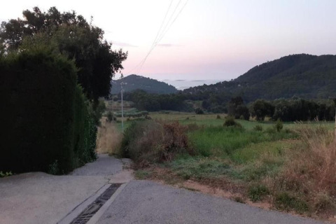 View of fields and hills from a road near Resort Begur 3 in Spain, taken during sunset.