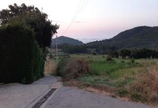 View of fields and hills from a road near Resort Begur 3 in Spain, taken during sunset.