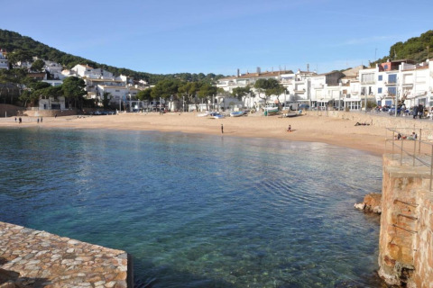 Vue depuis le safari tent Resort «Begur 4» en Espagne, avec plage paisible, eau claire et maisons blanches.