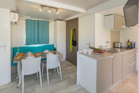 Lyst køkken- og spisestueområde i CAMPING INTERPALS- Bungalow Sa Riera, Spanien, med moderne indretning.
