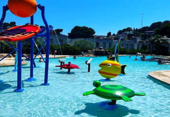 Piscine ludique avec jeux d’eau colorés pour enfants au Camping Interpals, Espagne, pendant une journée ensoleillée.