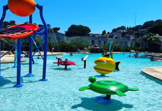 Billedet viser en børnevenlig swimmingpool med farverige vandlegepladser på Camping Interpals i Spanien.
