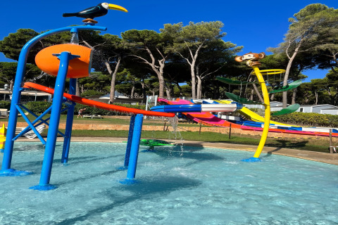Børnevenligt vandland ved CAMPING INTERPALS-Bungalow Sa Riera i Spanien med farverige rutsjebaner og figurer.