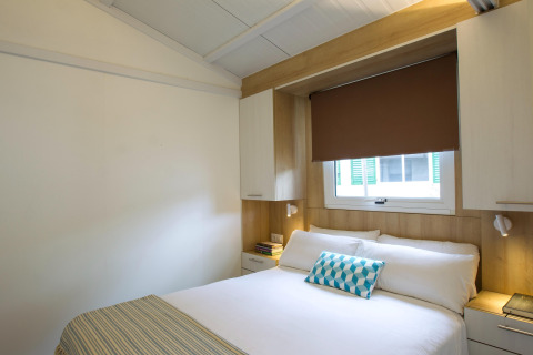 Slaapkamer in Tamarit Park Resort 1 THALASSA, Spanje, met een tweepersoonsbed en strakke moderne inrichting.