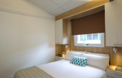 Camera da letto luminosa al Tamarit Park Resort 1 THALASSA, Spagna, con letto matrimoniale e arredo moderno.