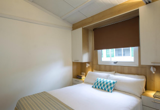 Slaapkamer in Tamarit Park Resort 1 THALASSA, Spanje, met een tweepersoonsbed en strakke moderne inrichting.