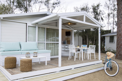 Udendørs opholdsområde af chalet på Tamarit Park Resort 1 THALASSA i Spanien med siddeplads og cykel.