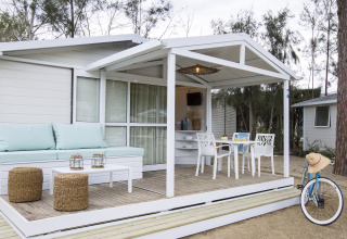 Udendørs opholdsområde af chalet på Tamarit Park Resort 1 THALASSA i Spanien med siddeplads og cykel.