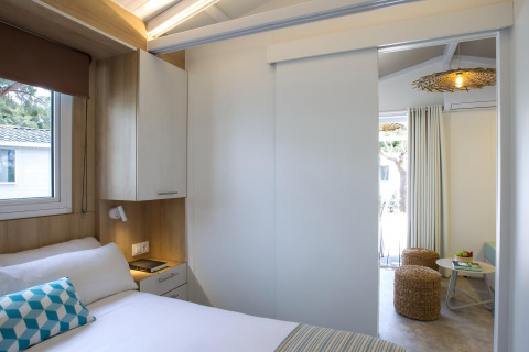 Moderne soveværelse og opholdsområde med skydedør i chalet på Tamarit Park Resort i Spanien.
