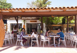 Mensen genieten van eten en drinken op het terras van Tamarit Park Resort 1 THALASSA in Spanje.