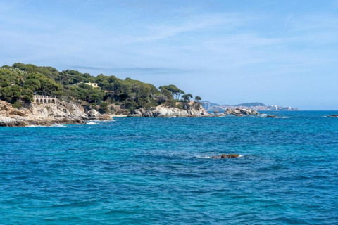Kystbillede taget fra Camping Interpals- Bungalow Sa Riera i Spanien, med klipper og blåt hav.