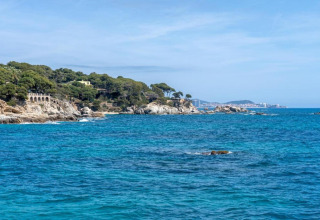 Kystbillede taget fra Camping Interpals- Bungalow Sa Riera i Spanien, med klipper og blåt hav.