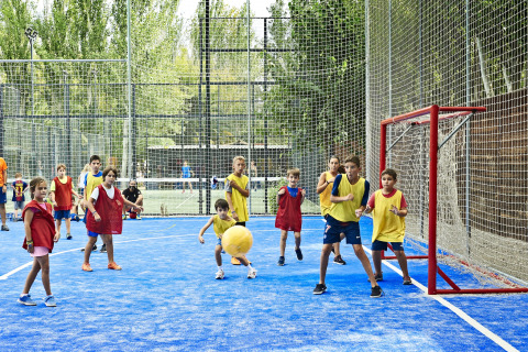 Kinderen spelen een balspel op een buitensportveld bij Tamarit Park Resort 1 THALASSA in Spanje.