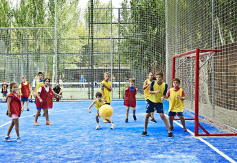 Bambini giocano a palla in un campo sportivo all'aperto al Tamarit Park Resort 1 THALASSA in Spagna.