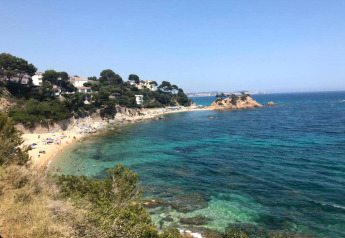 Vue sur la plage et la mer bleue depuis Camping Interpals- Bungalow Sa Riera en Espagne.