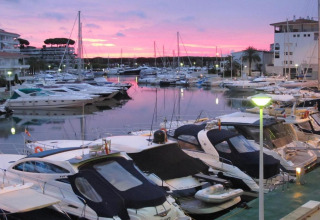 Både ligger fortøjet i en marina ved solnedgang nær Camping Interpals- Bungalow Sa Riera, Spanien.