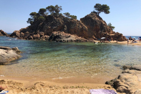 Smuk udsigt over stranden og de klippefyldte øer ved Camping Interpals- Bungalow Sa Riera i Spanien.