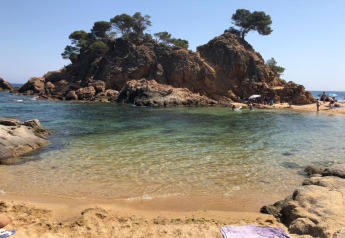 Prachtig zicht op strand en rotsige eilanden bij Camping Interpals- Bungalow Sa Riera in Spanje.