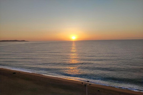 Solopgang over havet set fra Camping Interpals Bungalow Sa Riera i Spanien, med rolig strand og blødt lys.